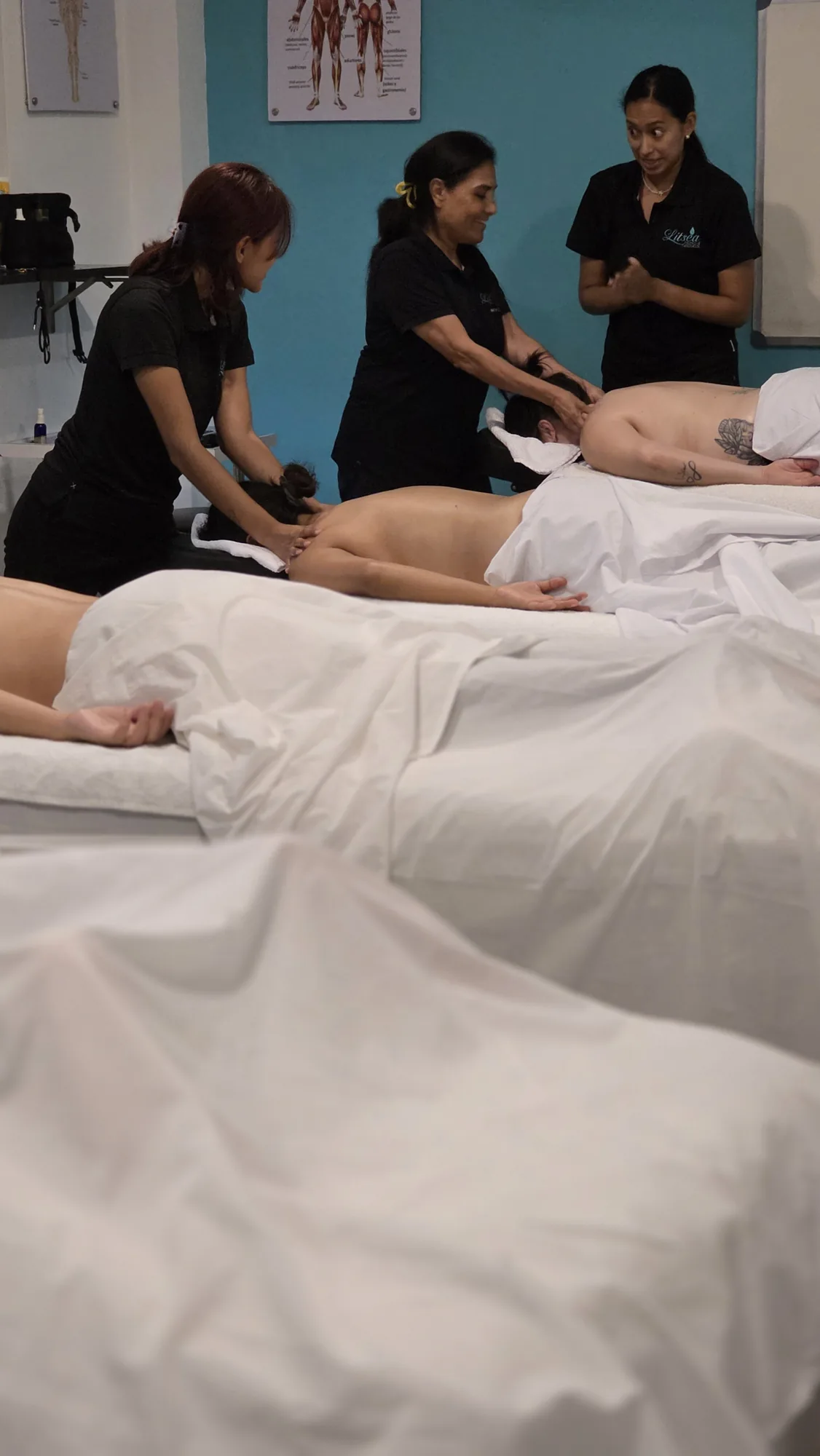 Docente de Litsea explicando una práctica junto a láminas de anatomía